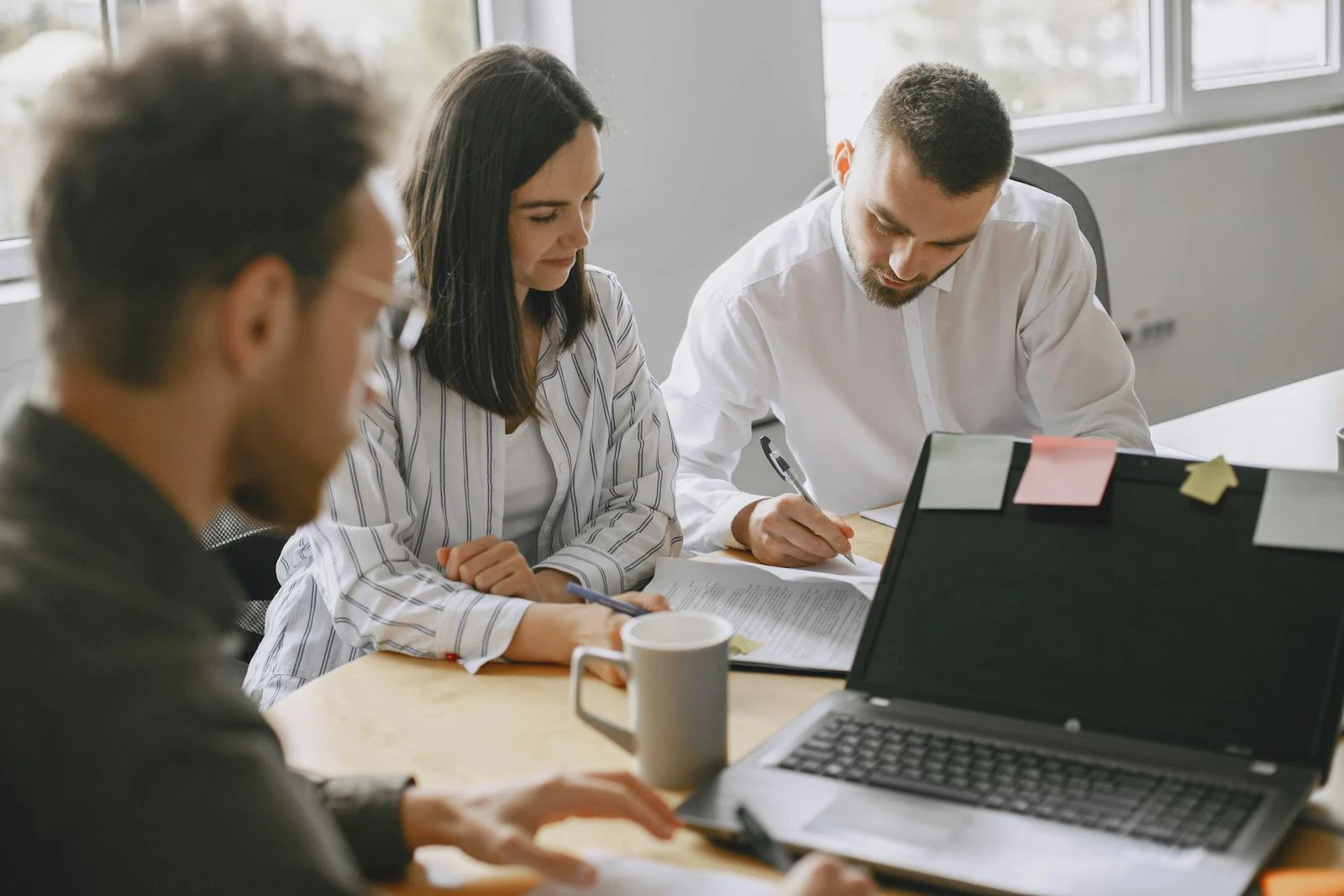 Focused team discussing work in a bright modern office environment.