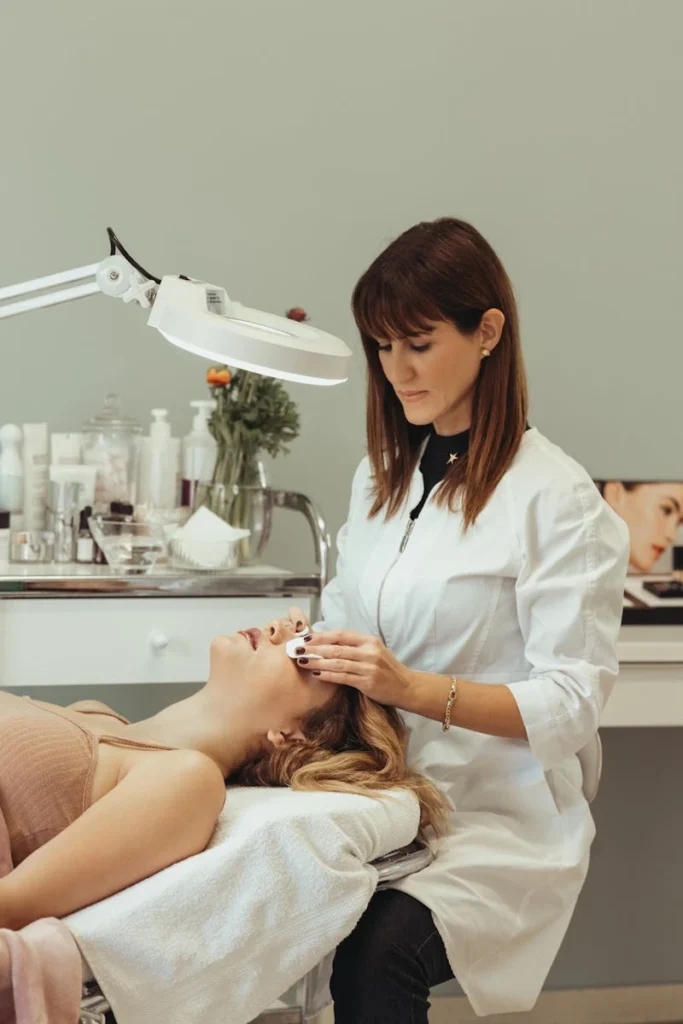 A cosmetologist performing skincare procedures on a client in a salon setting.