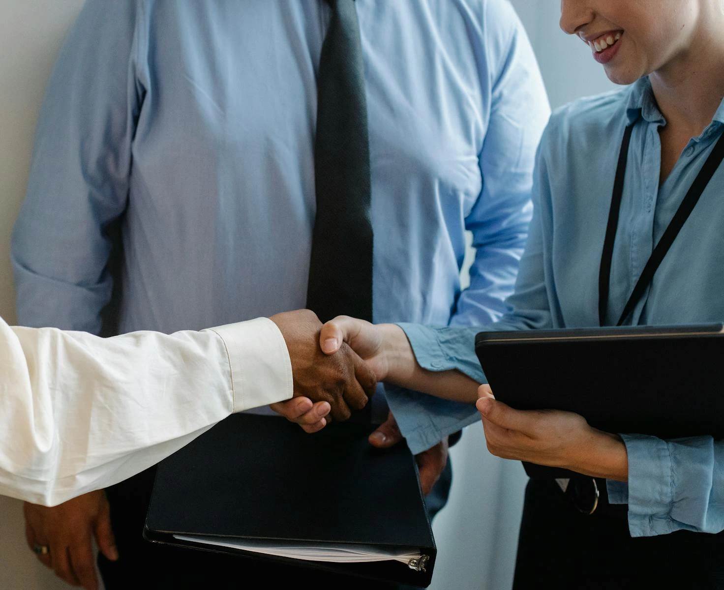 Close-up of business professionals shaking hands during a meeting in a modern office.