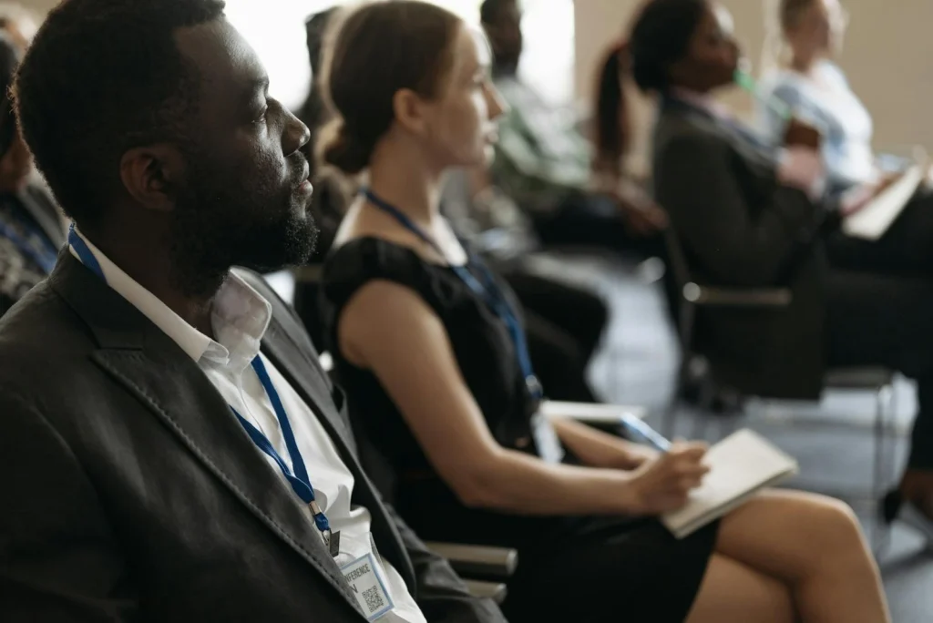 A diverse group of professionals attentively listening at a conference seminar.